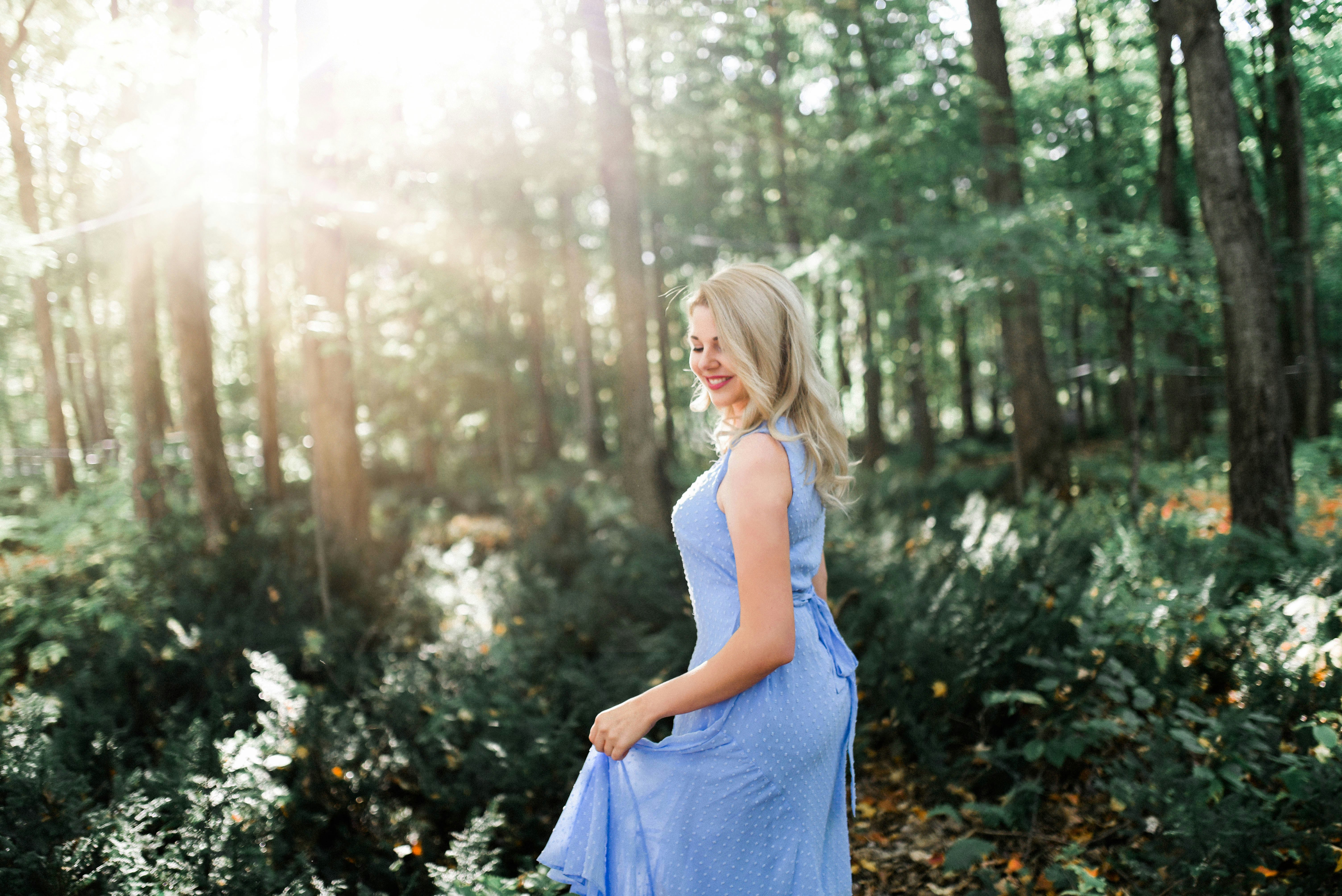 woman smiling and standing in the forest